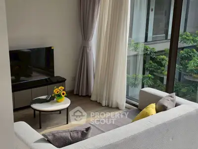 Modern living room with large window and cozy sofa, featuring a TV and stylish decor.