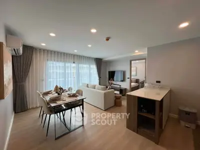 Modern open-plan living room with dining area and kitchen in a stylish apartment.