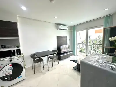 Modern living room with balcony access and sleek furniture in a bright apartment.