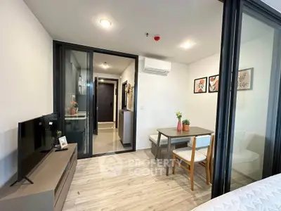 Modern apartment interior with open living and dining area, featuring sleek design and natural light.
