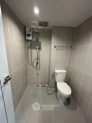 Modern bathroom with sleek tile design and shower area in a contemporary apartment.