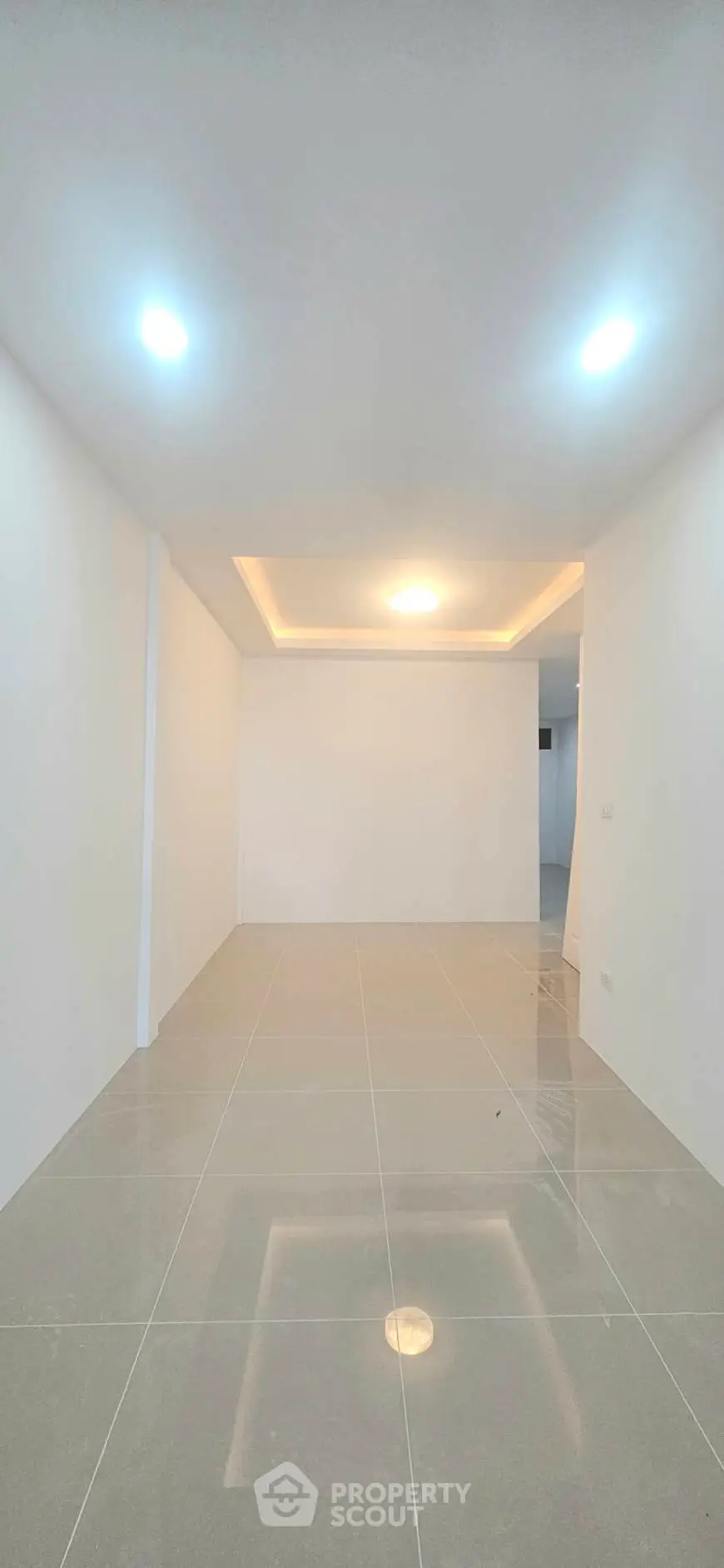 Spacious modern living room with sleek tile flooring and recessed lighting