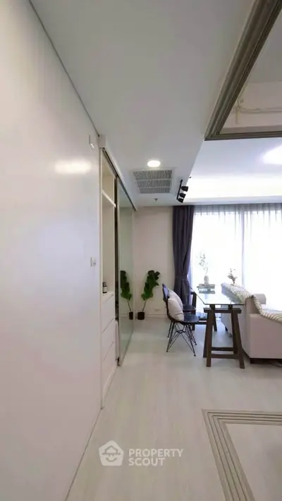 Modern living room with elegant decor and natural light, featuring cozy seating and stylish furnishings.