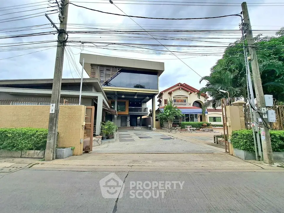Modern architectural house exterior with spacious driveway and lush greenery.