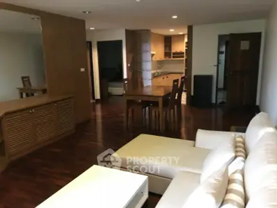 Spacious living room with elegant wooden flooring and modern furniture in a stylish apartment.