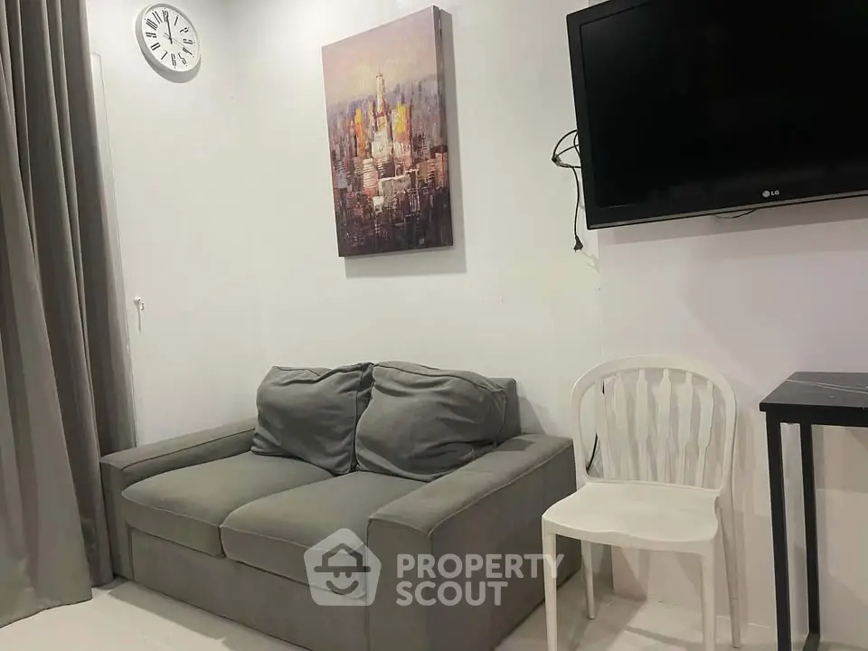 Cozy living room with modern decor, featuring a comfortable sofa, wall-mounted TV, and stylish artwork.