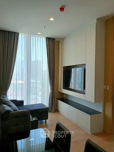 Modern living room with floor-to-ceiling windows and sleek built-in TV unit