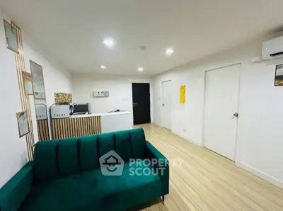 Modern living room with stylish green sofa and sleek wooden flooring