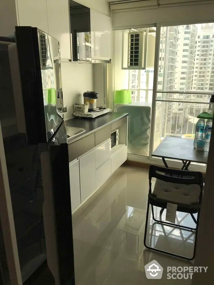 Modern kitchen with sleek cabinets and balcony view in urban apartment