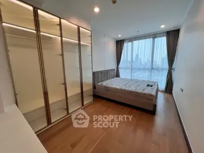 Spacious bedroom with city view and elegant wooden flooring