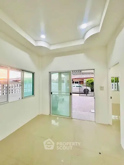 Bright and spacious living room with sliding glass doors leading to a patio, perfect for natural light.