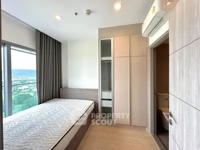 Modern bedroom with large window and scenic view, featuring built-in wardrobe and air conditioning.