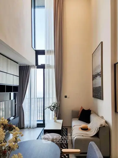 Elegant modern living room with high ceilings and large windows offering stunning views.