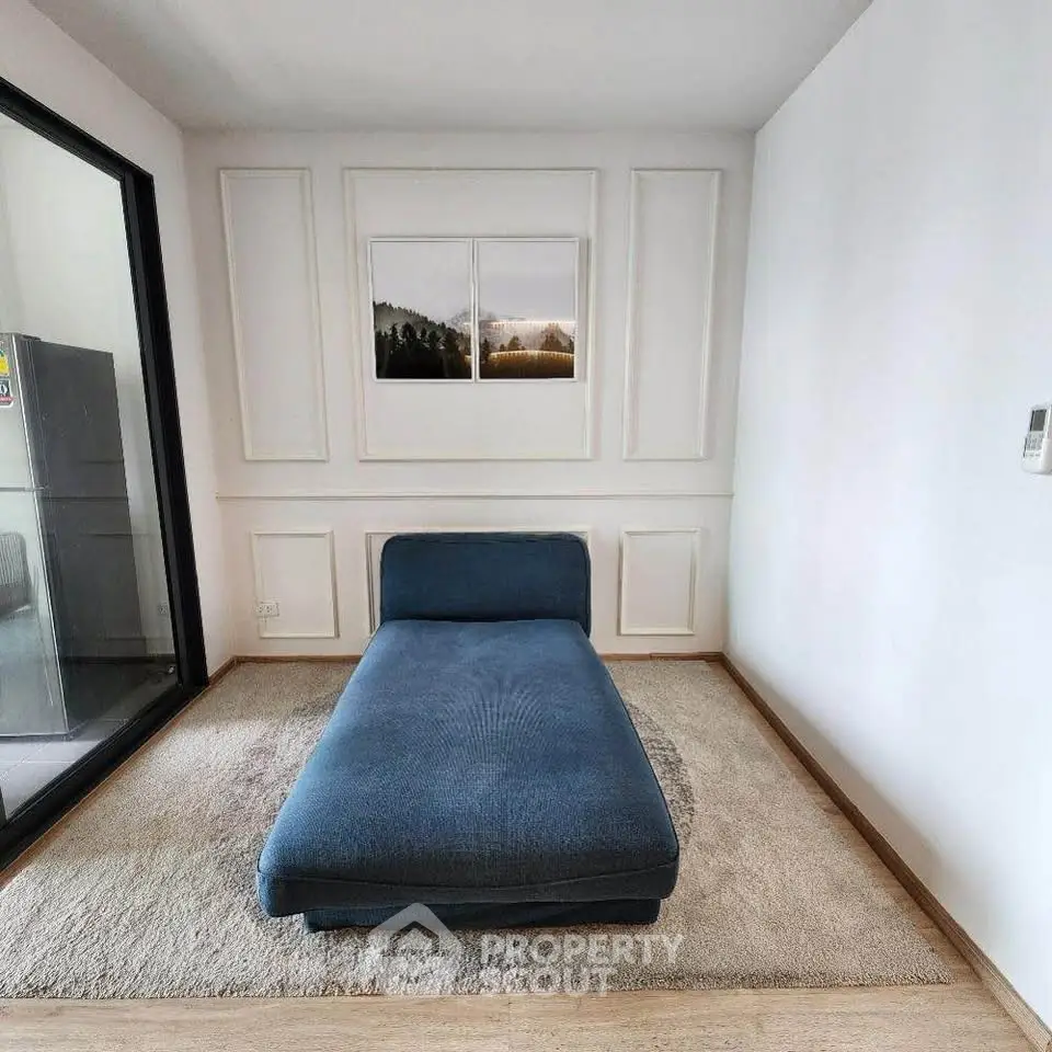 Modern minimalist living room with blue chaise lounge and elegant wall paneling.