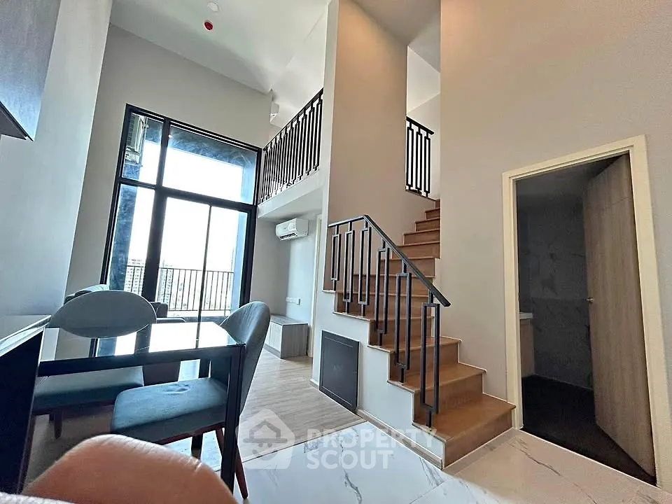 Modern duplex interior with high ceilings and stylish staircase