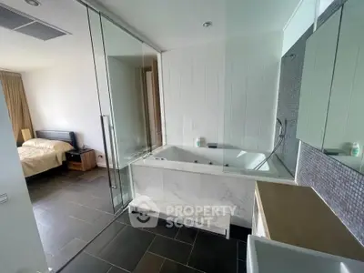 Luxurious modern bathroom with bathtub and adjacent bedroom in a stylish apartment.