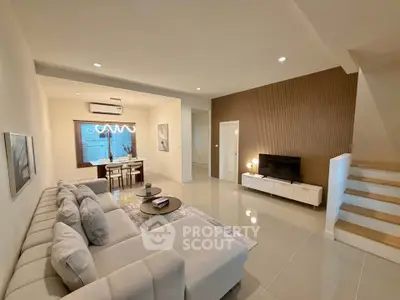 Spacious modern living room with elegant decor and open dining area, perfect for family gatherings.
