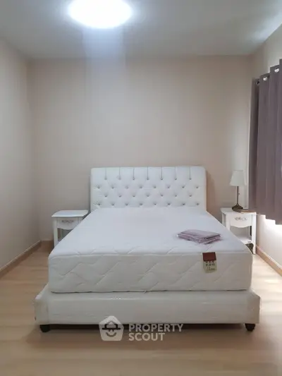 Spacious bedroom with elegant white bed and nightstands, perfect for a cozy retreat.