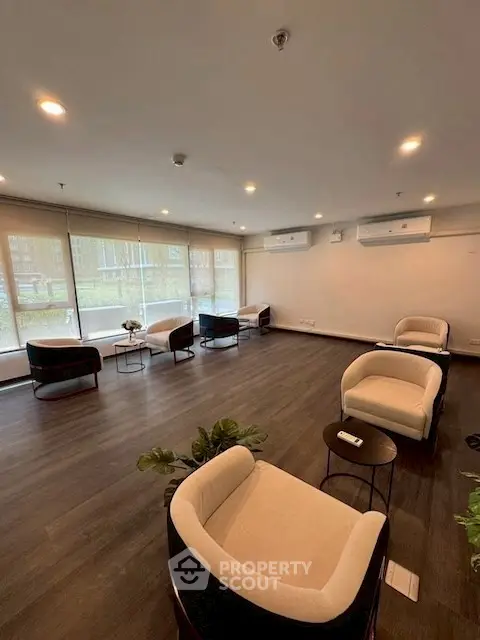 Spacious modern living room with elegant seating and large windows.