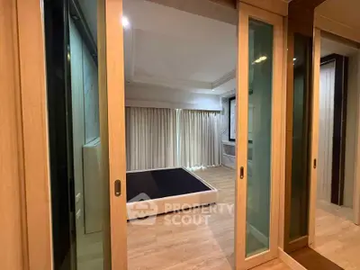 Spacious bedroom with sliding glass doors and elegant wooden flooring