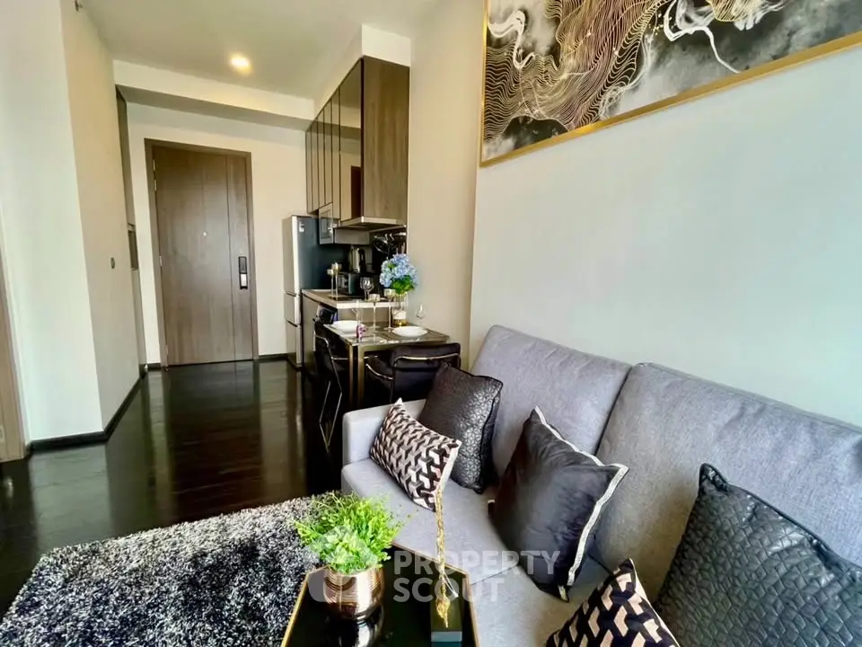 Modern living room with sleek kitchen, stylish decor, and cozy seating in a contemporary apartment.