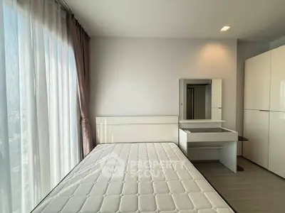 Modern bedroom with large window and sleek furniture in a high-rise apartment.