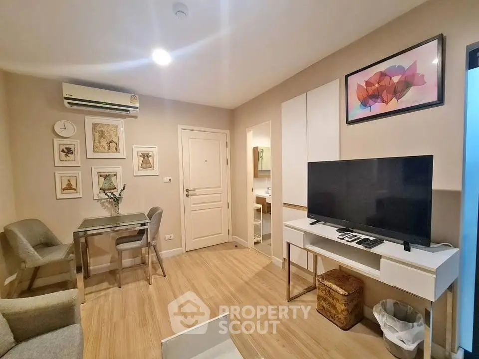 Modern living room with stylish decor, featuring a TV, dining area, and contemporary artwork.