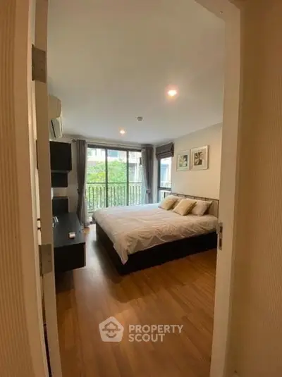 Spacious bedroom with large window and modern decor in a stylish apartment.