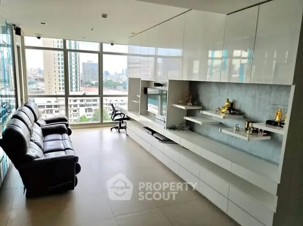Spacious modern living room with sleek built-in storage and panoramic city views.
