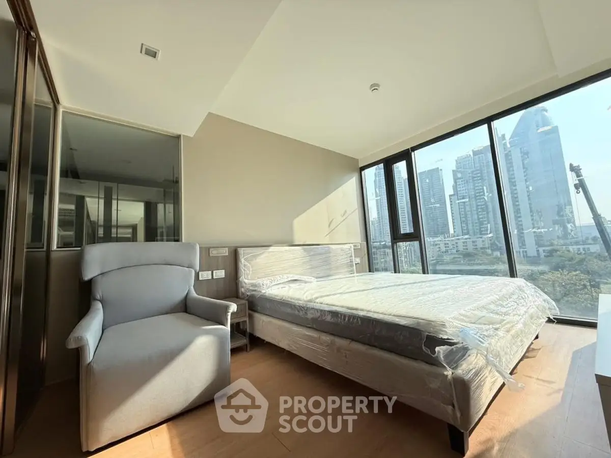 Modern bedroom with city view and large windows in high-rise apartment
