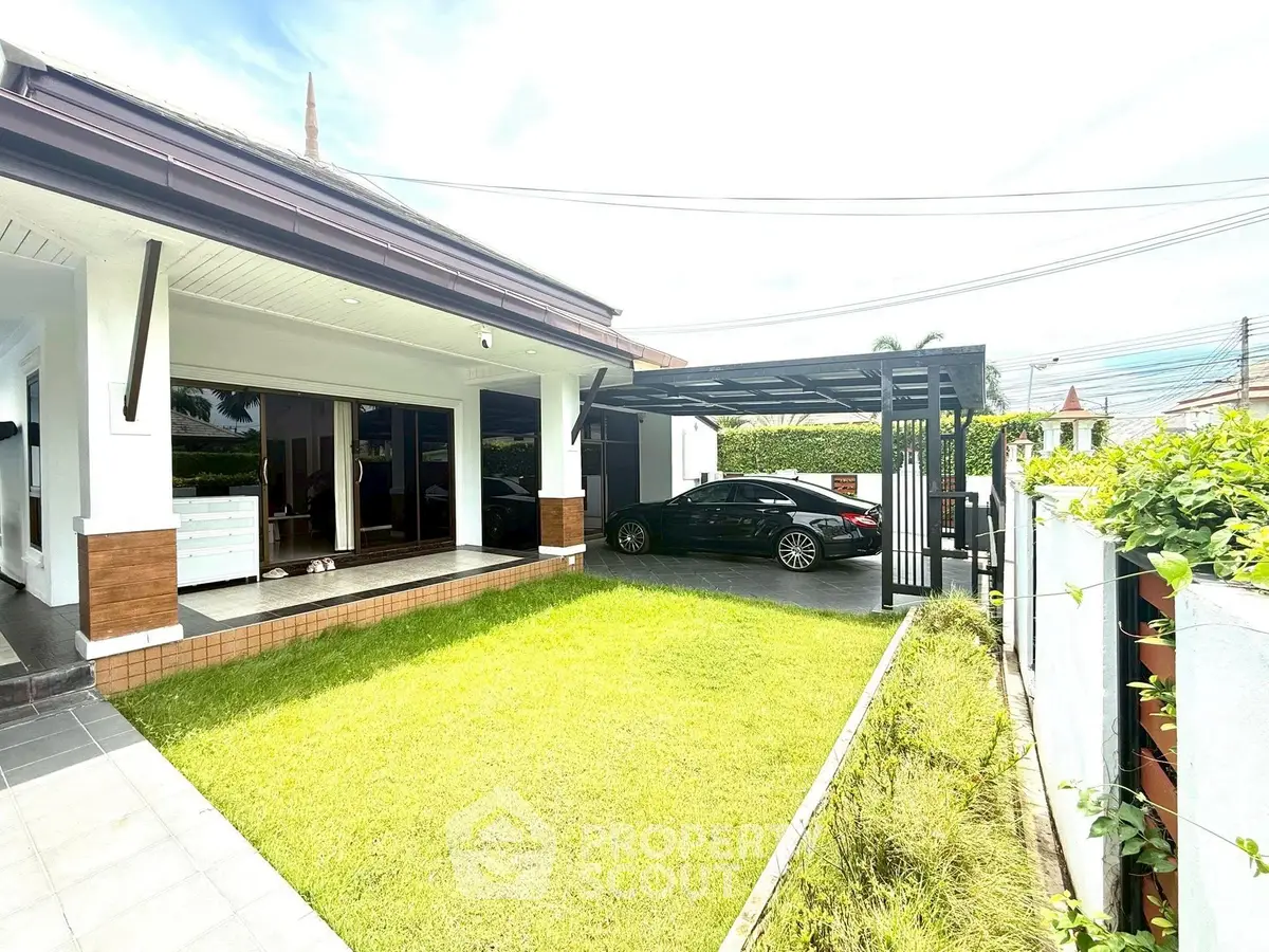 Charming modern house with lush garden and carport in serene neighborhood.