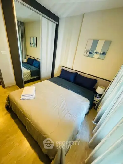 Cozy bedroom with mirrored wardrobe and stylish decor in modern apartment