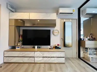 Modern living room with sleek TV unit and air conditioning, featuring stylish decor and ample storage.