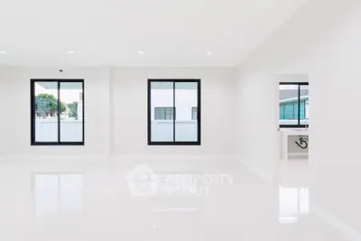 Spacious modern living room with large windows and bright natural light.