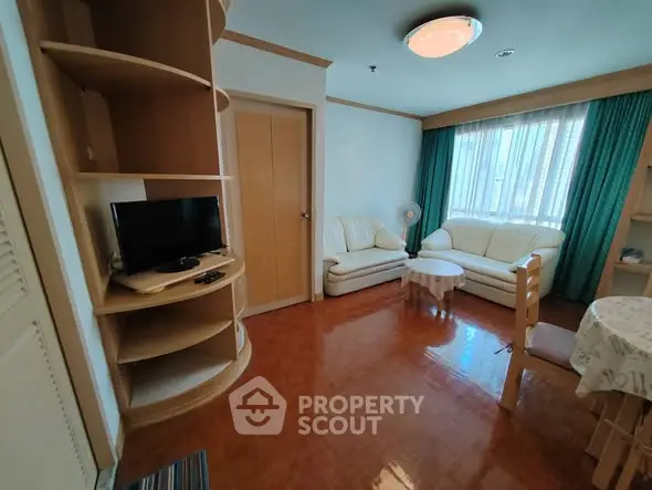 Cozy living room with natural light, wooden flooring, and modern furniture in a stylish apartment.