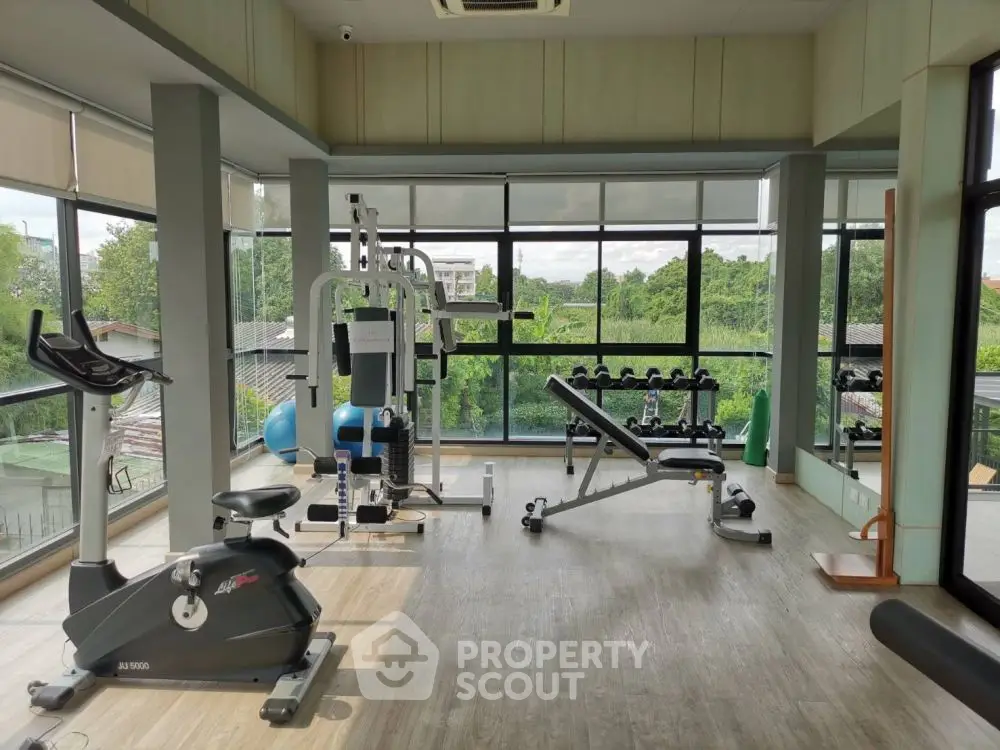 Spacious gym with modern equipment and scenic views, perfect for fitness enthusiasts.