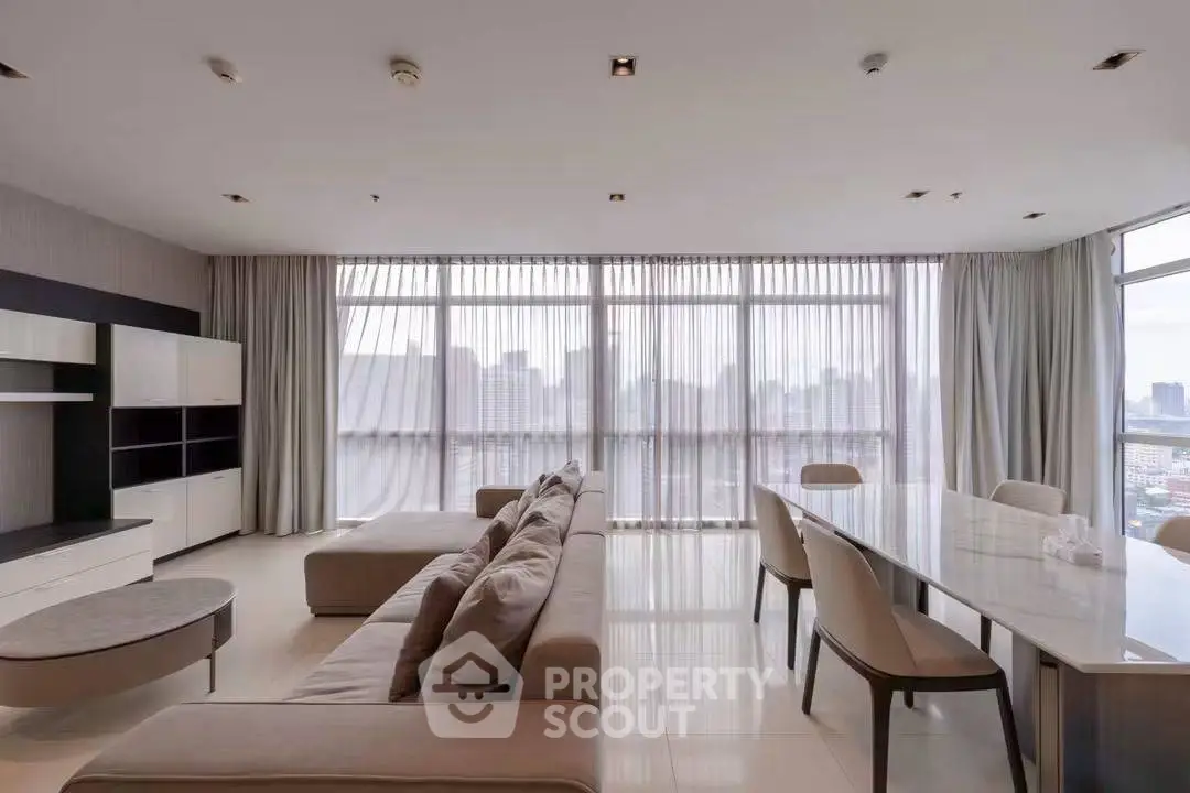 Spacious modern living room with panoramic city views and elegant dining area.