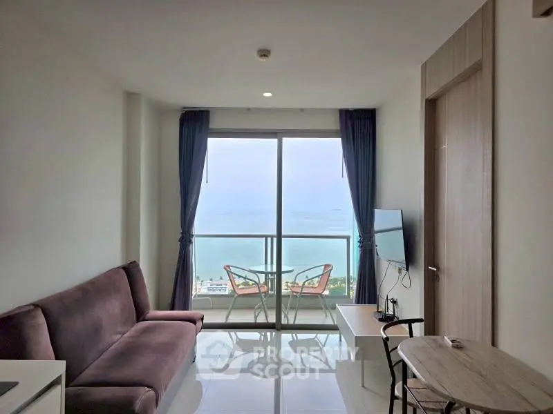 Modern living room with stunning sea view, featuring sleek furniture and large windows for natural light.