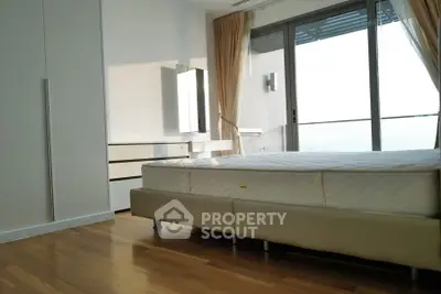 Modern bedroom with large windows and hardwood floors