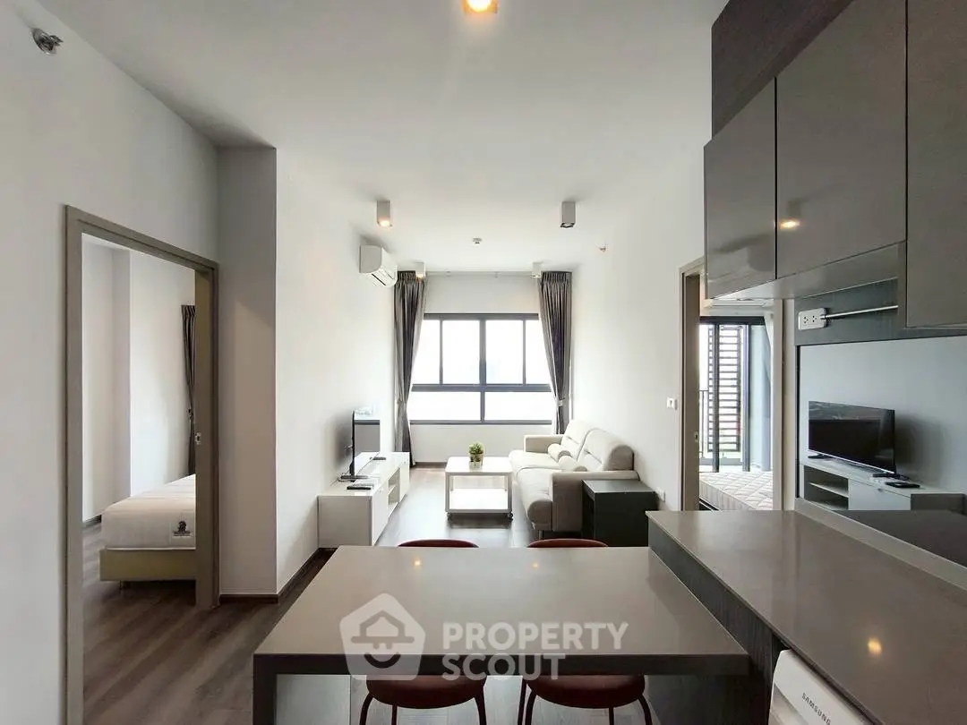 Modern open-plan living room with sleek kitchen and cozy seating area