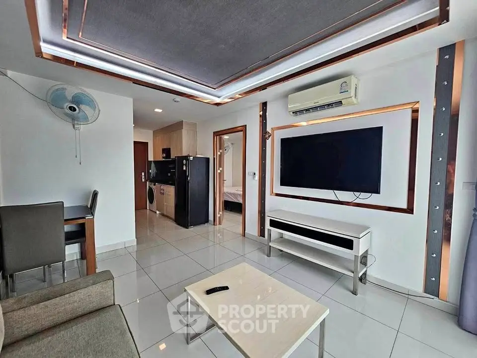 Modern living room with sleek design, featuring a wall-mounted TV and stylish ceiling lights.