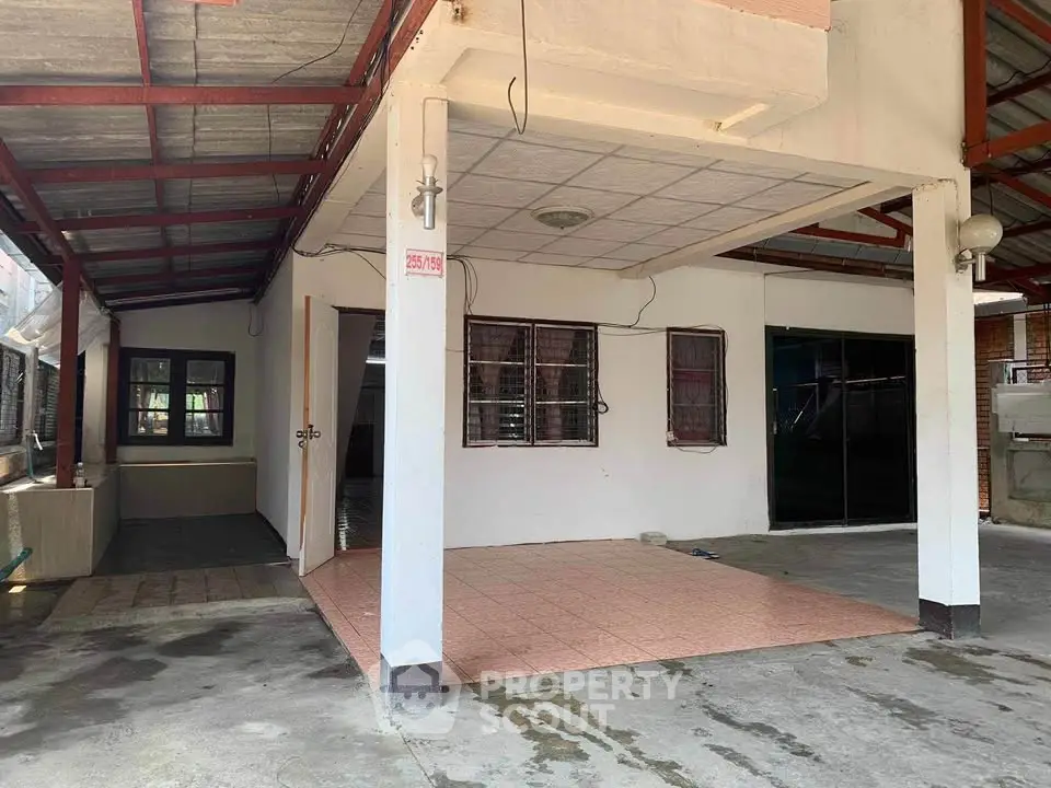 Spacious covered outdoor area with tiled flooring and ample natural light.