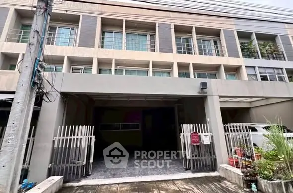 Modern townhouse exterior with gated entrance and multiple balconies.