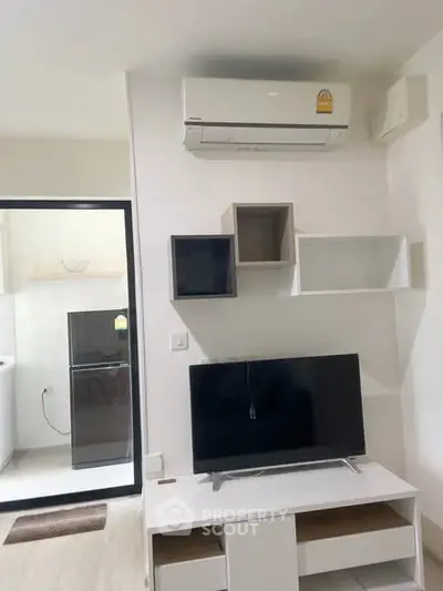 Modern living room with wall-mounted TV and air conditioning in a stylish apartment.