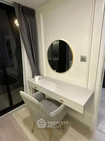 Elegant bedroom corner with modern vanity and plush chair near window