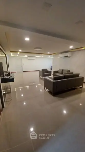 Spacious modern living room with sleek furniture and ambient lighting, perfect for relaxation and entertainment.