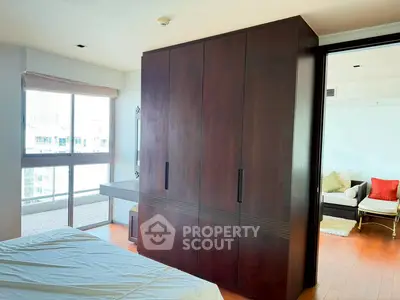 Spacious bedroom with large wardrobe and balcony view in modern apartment