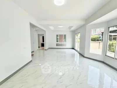 Spacious modern living room with large windows and marble flooring