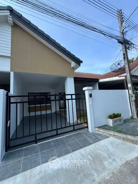 Charming single-story home with modern gate and driveway in a serene neighborhood.