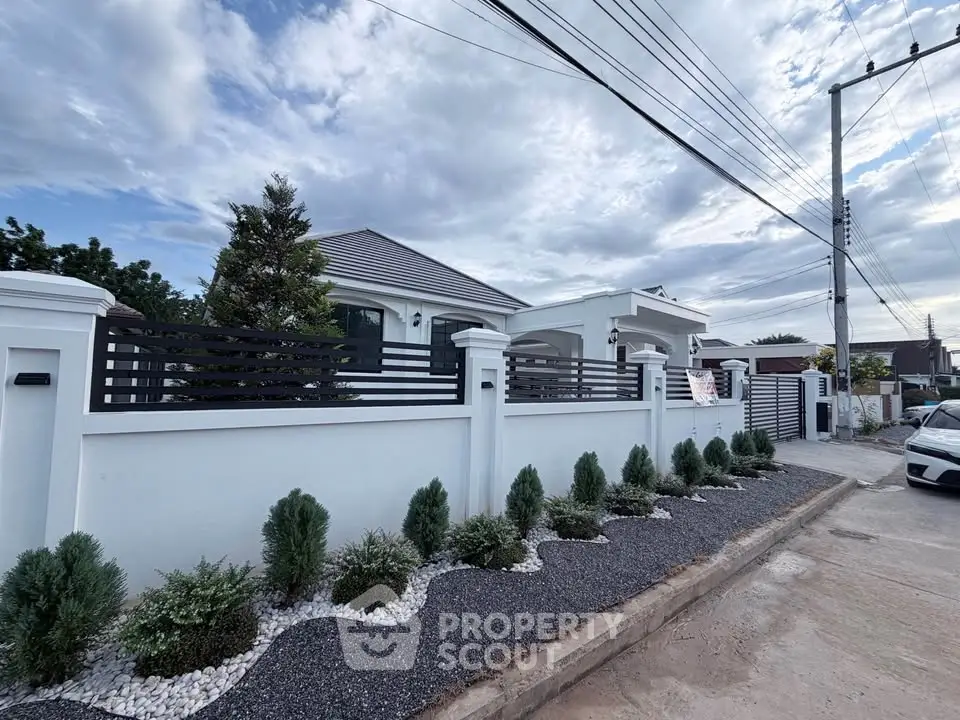 Modern single-story house with landscaped garden and sleek fence design.